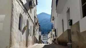 an alley with buildings and a mountain in the background at Casa TRIGO in Cómpeta