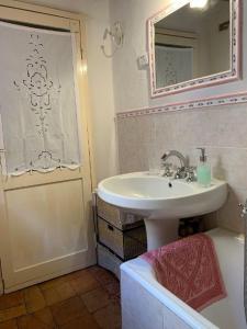 ein Bad mit einem Waschbecken und einem Spiegel in der Unterkunft Dimora Toscana in Seggiano