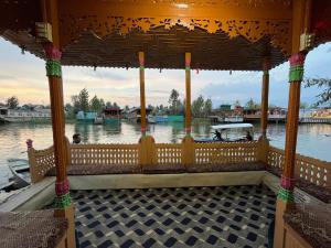 a gazebo on the water with a boat at New Silver Jubilee Heritage Group Of Houseboats in Srinagar
