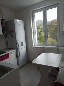 a kitchen with a white table and a window at Apartament două camere in Uricani