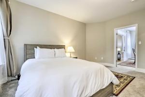 a bedroom with a large bed with white sheets at 2 Mi to Downtown: Springfield Apt w/ Balcony! in Springfield