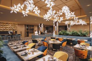 um restaurante com mesas, cadeiras e lustres em Fortune Walkway Mall, Haldwani - Member ITC's Hotel Group em Haldwani