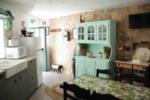 a kitchen with blue cabinets and a table and a refrigerator at Casa Beatriz in Alge