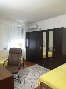 sypialnia z krzesłem, łóżkiem i oknem w obiekcie Apartment Marsala Tita w Barze