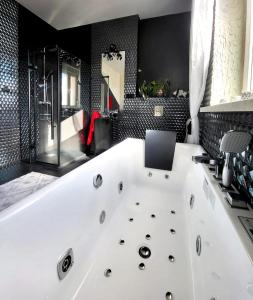 een badkamer met een wit bad en een laptop. bij Lupus Apartamenty in Poznań