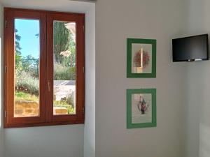a room with a window and a television on a wall at appartamento Bel Salino in Macerata