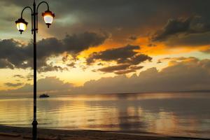 une lumière de rue sur la plage avec un coucher de soleil dans l'établissement nana, à Peraia
