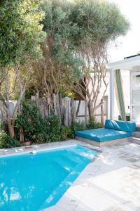 a swimming pool in a yard with trees at Driftwood by The Oyster Collection in Kenton on Sea