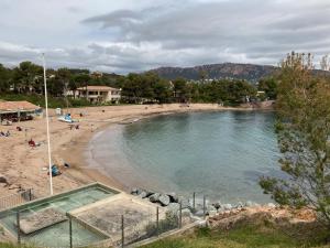una spiaggia con una piscina d'acqua e persone di Cap Estérel, 2 pièces, jardin, vue mer et piscine ad Agay - Saint Raphael