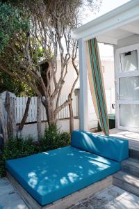 Driftwood by The Oyster Collection في كينتون اون سي: أريكة زرقاء على شرفة مع نافذة