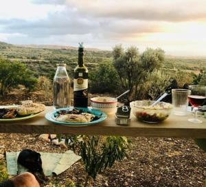 a table with plates of food and a bottle of wine at East woodhouse in Clil