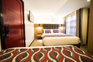 a hotel room with two beds and a door at UNWND Boutique Hotel Makati in Manila