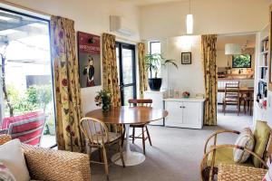 a living room with a table and a kitchen at Magnolia House in Blenheim