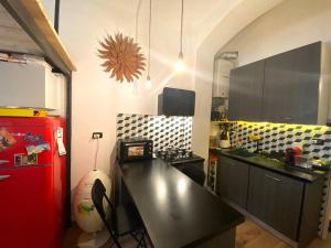 cocina con encimera negra y nevera roja en LoftMongrando43, en Turín