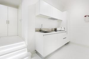 a kitchen with white cabinets and a sink at White Stylish Apartment 3 in Vico Equense