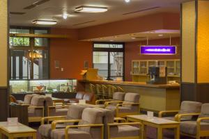 a waiting room with chairs and tables and a bar at Hotel Gujo Hachiman in Gujo