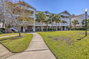 a large white building with trees in front of it at Barefoot Landing Retreat with Resort Amenities! in Myrtle Beach