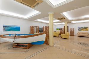 a museum with a boat on display in a room at Hotel Sabbia d'Oro in San Vito lo Capo