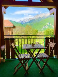 una mesa de picnic y 2 sillas en un balcón con montañas en LE NID DU BIRDIE, Giez, Proche du lac d’Annecy en Giez