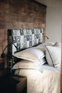 a bed with white pillows and a wooden headboard at The Oyster Box Beach House by The Oyster Collection in Kenton on Sea +84 photos