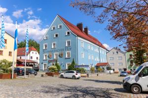 a blue building with cars parked in a parking lot at Schwarzacher Hof in Niederbayern in Schwarzach