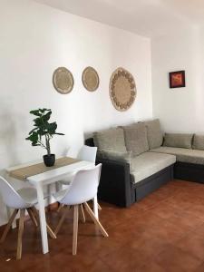 uma sala de estar com uma mesa e um sofá em Alojamientos Nicasio em Tejeda
