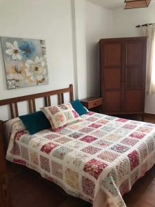 a bedroom with a bed with a quilt on it at Alojamientos Nicasio in Tejeda