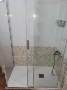 a shower with a glass door in a bathroom at Alojamientos Nicasio in Tejeda