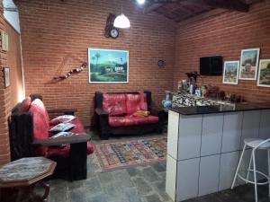 salon z czerwoną kanapą i krzesłem w obiekcie Casa de campo serrana, alegre e com piscina w mieście Lindóia