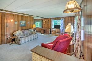 sala de estar con silla roja y sofá en Riverfront Suring Home ATV Trails, Sunroom! 