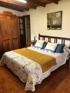 a bedroom with a large bed with blue and white pillows at Alojamientos Nicasio in Tejeda