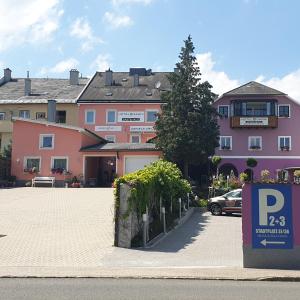 un estacionamiento con una señal de estacionamiento frente a un edificio en Hotel Garni Daniela Urich, en Schwanenstadt