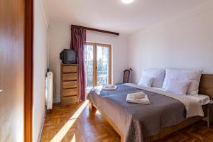 sypialnia z łóżkiem, telewizorem i oknem w obiekcie Peregrino Panzió w mieście Budaörs