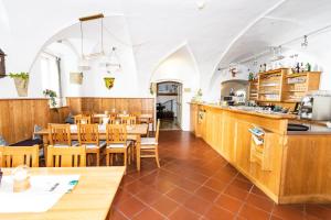 restauracja z drewnianymi stołami i krzesłami oraz blatem w obiekcie Schwarzacher Hof in Niederbayern w mieście Schwarzach