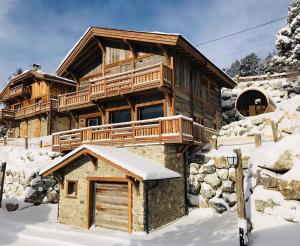 una cabaña de madera en la nieve con garaje en Chalet Vista - bolquère, en Bolquere Pyrenees 2000