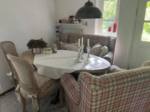 uma mesa de jantar com uma toalha de mesa branca e 2 cadeiras em Kruemelkate em Witzwort