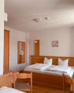 1 dormitorio con 1 cama, mesa y sillas en Schwarzacher Hof in Niederbayern en Schwarzach
