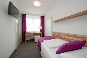 ein Hotelzimmer mit 2 Betten und einem TV in der Unterkunft Happy Lake by Thomas Strugger in Krumpendorf am Wörthersee