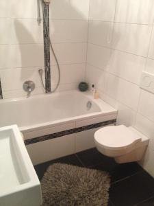 a bathroom with a tub and a toilet and a sink at Apartment Renate Strohhöfer in Hirschaid