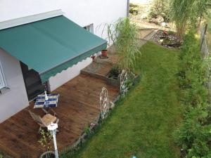 eine Aussicht auf eine Terrasse mit blauer Markise in der Unterkunft Apartment Renate Strohhöfer in Hirschaid