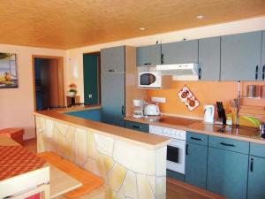 eine Küche mit blauen Schränken und einer Arbeitsplatte in der Unterkunft Picturesque Apartment in Lichtenhain with Pond in Lichtenhain