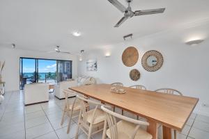 a dining room and living room with a table and chairs at Stunning 2-3 Bed Penthouse Glorious Ocean Views in Trinity Beach