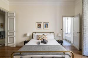 La Maison de L' Ambassadeur Carcassonne في قرقشونة: غرفة نوم بسرير ابيض كبير ومصباحين