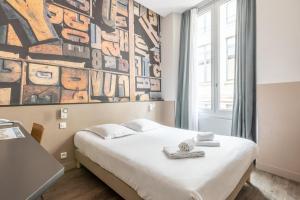 ein Schlafzimmer mit einem Bett und einem Wandgemälde in der Unterkunft Hotel de la Presse Bordeaux Centre in Bordeaux