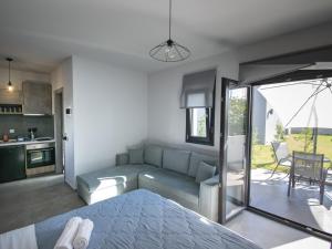 ein Wohnzimmer mit einem Sofa und einer Küche in der Unterkunft TheaSea Luxury Suites - Kallikrateia Halkidiki in Nea Kallikratia