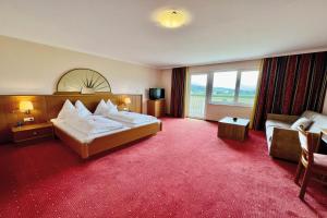 a hotel room with a bed and a couch at Hotel Pachernighof in Velden am Wörthersee