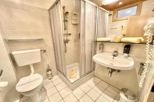 a bathroom with a toilet and a shower and a sink at Hotel Pachernighof in Velden am Wörthersee