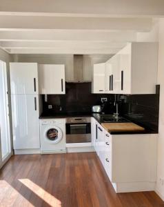 a kitchen with white cabinets and a dishwasher at Maison bohème à deux pas de l'océan in Lège-Cap-Ferret +10 photos