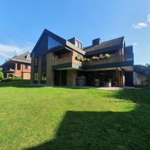 a large house with a large lawn in front of it at Förde Koje in Westerholz