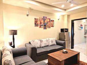 een woonkamer met een bank en een tafel bij Comfortable & Lovely 1 Bed Apt In Bahria Town in Rawalpindi